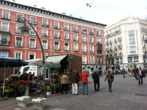a group of people walking around a market in a city at Casa de Huéspedes Prada in Madrid