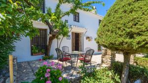 a patio with a table and chairs in front of a house at Cortijo Casablanca Priego de Cordoba by Ruralidays in Priego de Córdoba
