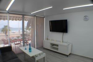 salon z kanapą i telewizorem na ścianie w obiekcie LOS RANCHOS PREMIUM Levante Beach w mieście Benidorm
