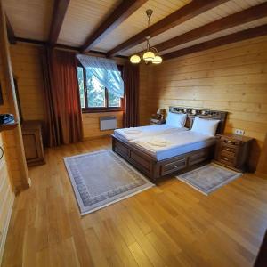 a bedroom with a bed in a wooden room at CHALETS GREY GOOSE in Yablunytsya