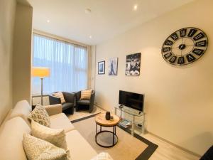 a living room with a couch and a clock on the wall at Vakantiehuis in het Centrum van Domburg DO19 in Domburg