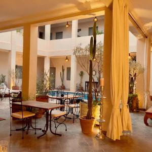 une terrasse avec des tables et des chaises ainsi qu'une piscine dans l'établissement Le Patio Du Lac, à Lalla Takerkoust