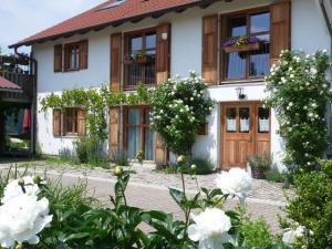 una casa con flores blancas delante de ella en Ferienwohnung Wild, en Maierhöfen