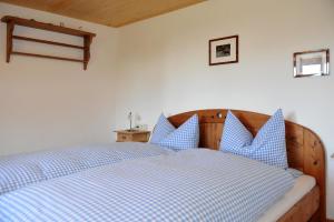 a bedroom with a blue and white bed with blue pillows at Ferienwohnung Wild in Maierhöfen