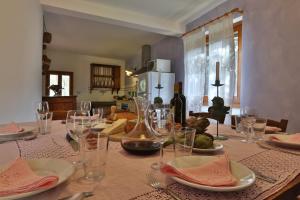 una mesa de comedor con vasos y platos. en Podere Il Doccio en Terranuova Bracciolini