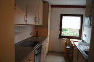 a small kitchen with a sink and a window at Ferienwohnung Bergisch Land in Wermelskirchen +8 photos