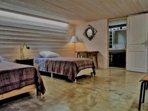 a bedroom with two beds and a table and a mirror at Maison cosy avec cour privative au cœur de l'Auvergne - FR-1-582-316 in Lempdes sur Allagnon