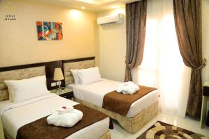 a hotel room with two beds with towels on them at Jewel Dokki Hotel in Cairo