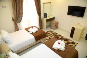 a hotel room with two beds and a television at Jewel Dokki Hotel in Cairo