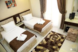 Jewel Dokki Hotel في القاهرة: غرفه فندقيه سريرين عليها مناشف