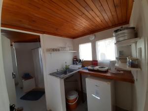 a small kitchen with a sink and a wooden ceiling at Allemann-se-Huisie in Nieu-Bethesda