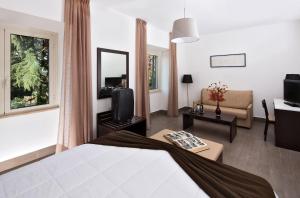 um quarto de hotel com uma cama e uma sala de estar em LH Hotel Excel Roma Montemario em Roma