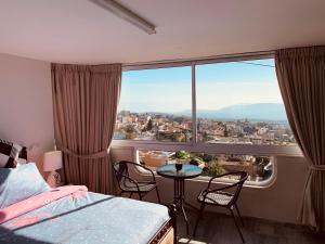 sypialnia z łóżkiem i stołem oraz dużym oknem w obiekcie מיאר אירוח דרוזי w mieście Maghār