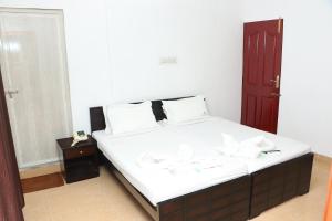 Swarna Sudarshan Service Apartment @ Adyar chennai tesisinde bir odada yatak veya yataklar