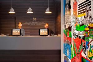 リバプールにあるHeeton Concept Hotel - City Centre Liverpoolの二人の男がコンピューターを持ってカウンターに座っている +21枚の写真