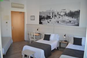 a hotel room with two beds and a desk and a bed at Hostal San Lorenzo in Madrid