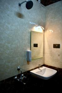 bagno con lavandino e specchio a parete di The First Light Inn a Kanchipuram