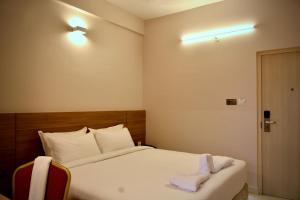 a hotel room with a bed with towels on it at The First Light Inn in Kanchipuram