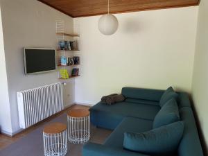 sala de estar con sofá azul y TV en Ferienhaus Brenzblick en Gundelfingen