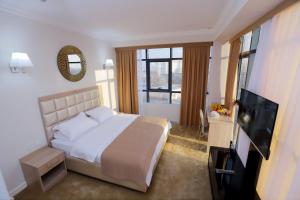 a bedroom with a bed and a flat screen tv at VELARA HOTEL in Tashkent