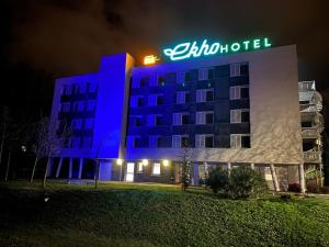 un hôtel avec un panneau en haut de celui-ci la nuit dans l'établissement Ekho Hotel Grenoble Nord Saint Egrève, à Saint-Égrève