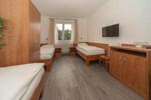 Hotel Panský dům في Blovice: غرفة مستشفى بسريرين وتلفزيون