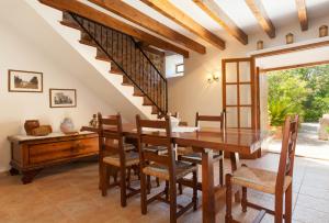 comedor con mesa de madera y sillas en Villa Butxaco, en Pollensa
