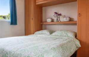 een slaapkamer met een bed met een groen dekbed en een raam bij Huis Nr, 5 in Woubrugge