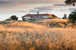 a house on top of a hill with tall grass at The Oxfordshire Golf & Spa Hotel in Thame