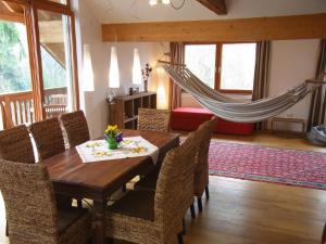 a dining room with a table and chairs and a hammock at Ferienwohnung Siloblick in Amstetten