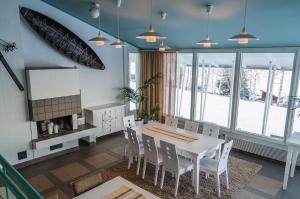 a dining room with a white table and chairs at Hotel Himos in Jämsä