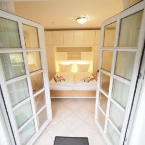 ein kleines Zimmer mit zwei Fenstern und einem kleinen Bett in der Unterkunft Mövennest in Westerland