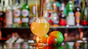 a drink in a glass sitting on a bar with fruit at Hotel Bankya Palace in Bankya