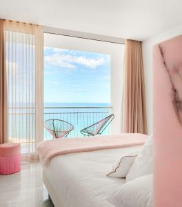 a bedroom with a large window with a view of the ocean at Hotel Aromar in Platja d'Aro