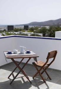 einen Holztisch und einen Stuhl auf einer Terrasse in der Unterkunft Villas del Mar Viña y Cabrera in Puerto Calero