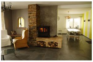 圣胡伯特Gîte Pause Nature Saint-Hubert的带壁炉的客厅和用餐室