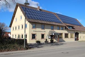 um edifício com painéis solares em cima em Schwarzer Adler em Schwaighausen