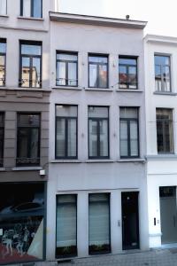 un bâtiment blanc avec de nombreuses fenêtres sur une rue dans l'établissement Klapdorp, à Anvers