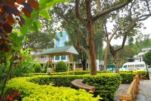 a park with a bench and trees and a building at Eastend Munnar in Munnar