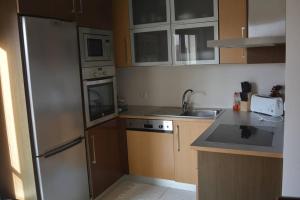 Una cocina con frigorífico de acero inoxidable y fregadero. en Casa Faria, en Senhora da Vitória