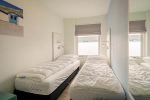 uma fila de camas sentadas num quarto em Appartementencomplex Juliana 130 em De Koog