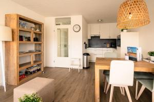 uma cozinha e sala de jantar com mesa e cadeiras em Appartementencomplex Juliana 130 em De Koog