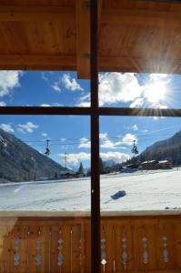 ein Fenster mit Blick auf ein schneebedecktes Feld von einer Hütte in der Unterkunft Hotel Starjet in Flachau