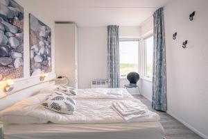 a bedroom with a bed and a window at Appartementencomplex Juliana 132 in De Koog