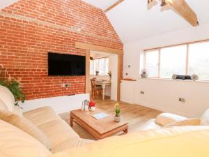 a living room with a brick wall at The Duck House in Thetford