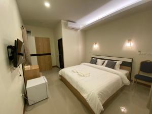 1 dormitorio con 1 cama grande y TV en Piumsuk Villa, en Satun