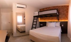 a bedroom with a bunk bed with a ladder at Liiv Costeira - Natal Ponta Negra in Natal