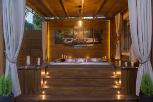eine Whirlpool-Badewanne in einem hölzernen Zimmer mit Beleuchtung in der Unterkunft LUNA HOME Jacuzzi Love Relax in Mutxamel