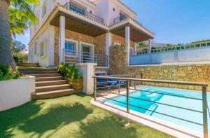 a villa with a swimming pool and a house at Bahamas 1 in Son Serra de Marina