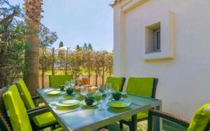 a table with green chairs on a patio at Bahamas 1 in Son Serra de Marina